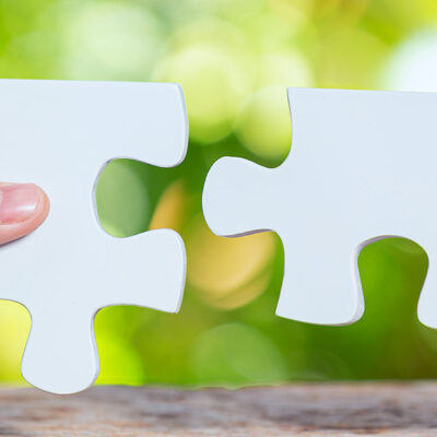 Twee handen met puzzelstukjes